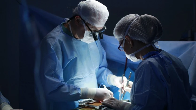 Surgeons performing a parathyroidectomy in a operating room